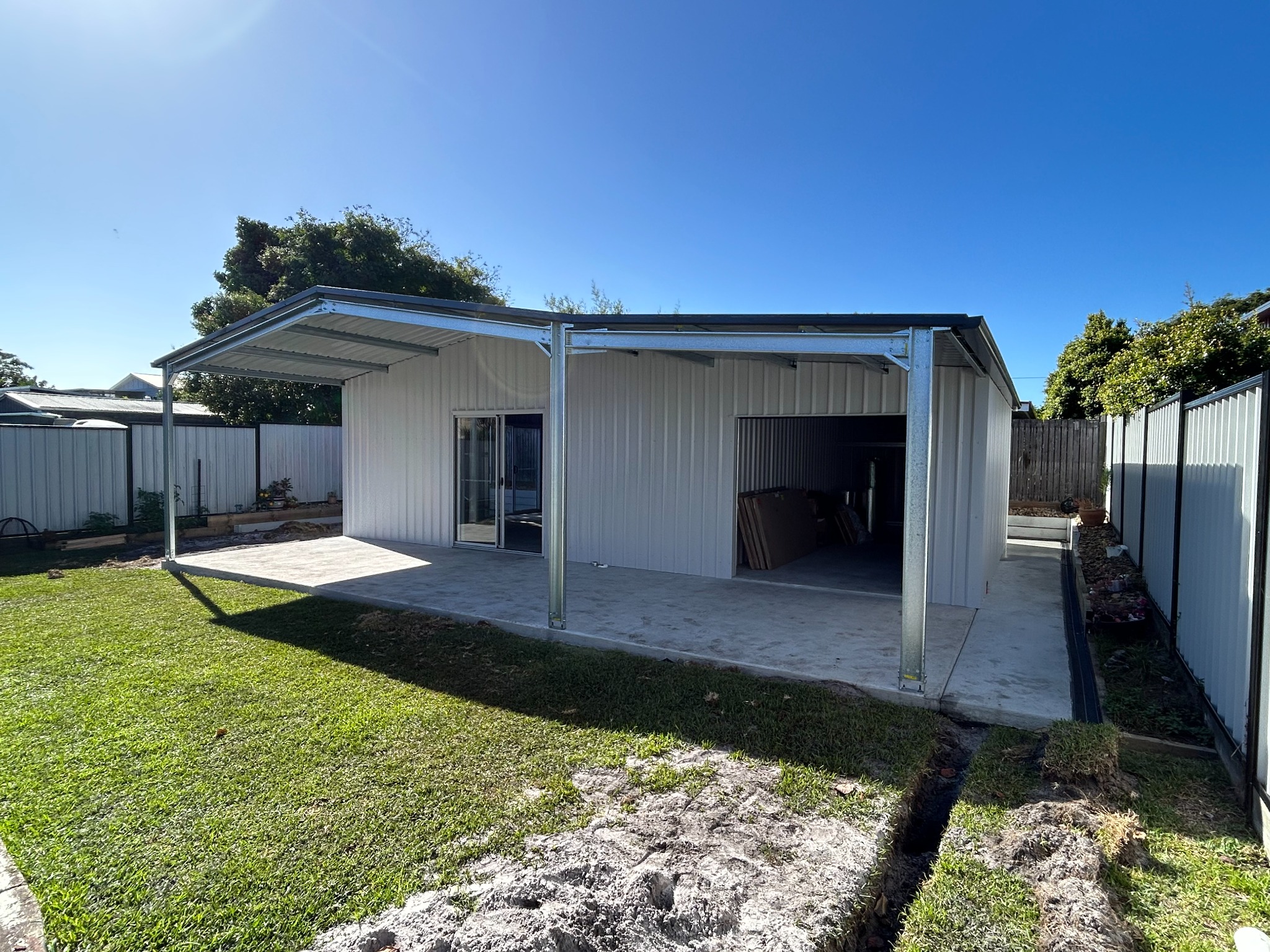 Backyard garage and covered patio by Superior Shed Market